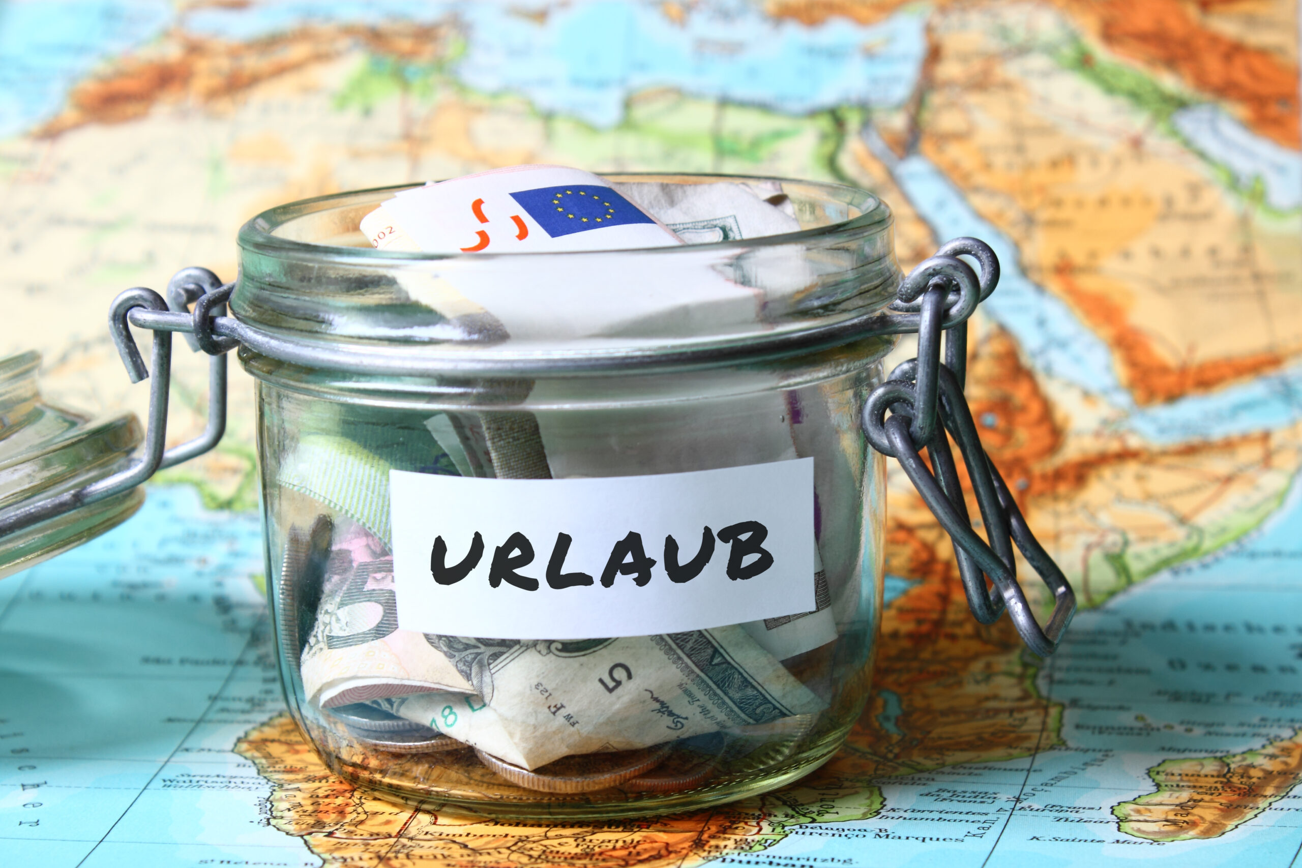 Urlaubsgeld verschiedene Währungen auf eine Weltkarte