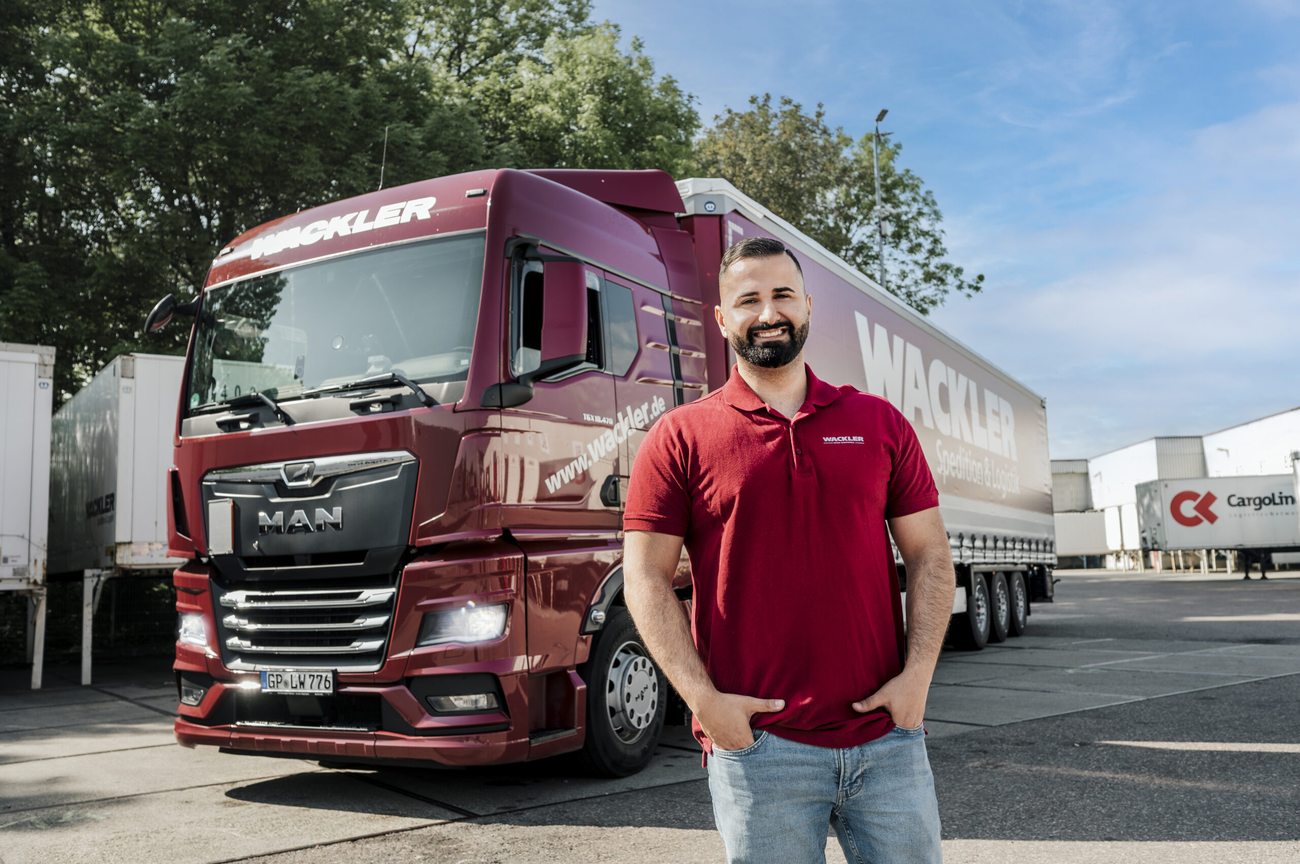 Ein Berufskraftfahrer und ein großer Lastwagen im Hintergrund